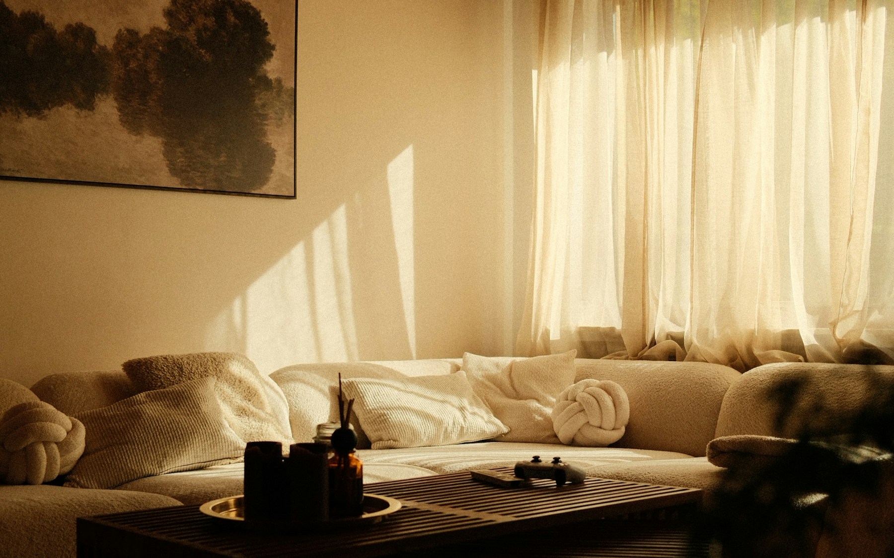 A light-filled living room with a neutral sofa, warm wood and natural textures